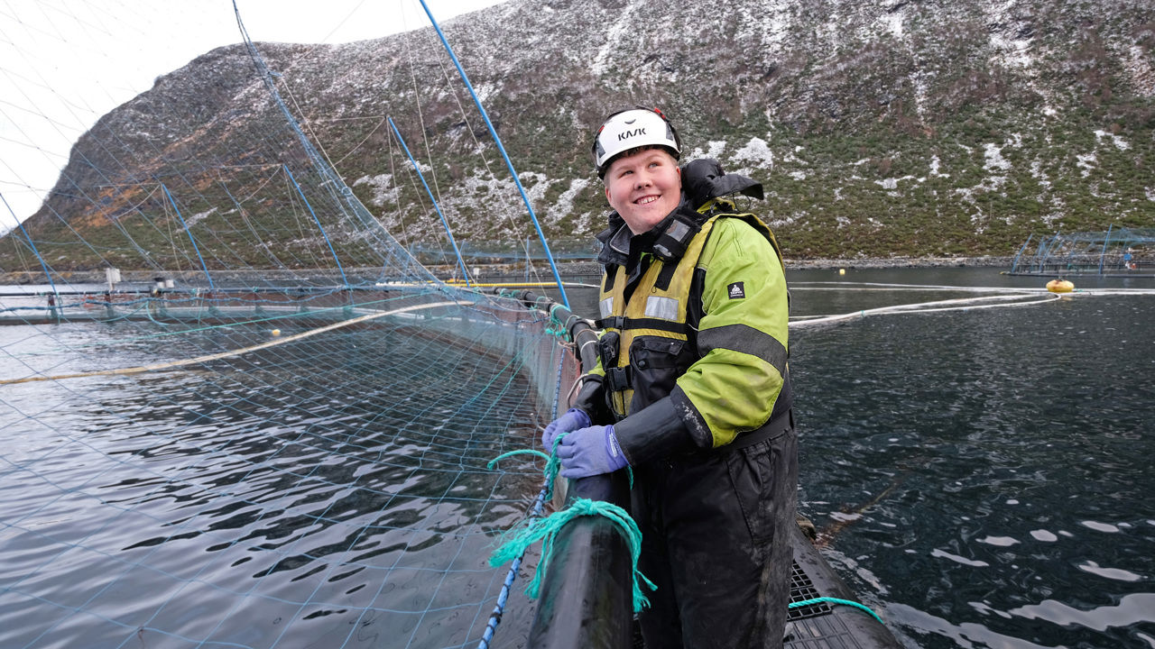 Elev som står ved eit fiskeopdrett